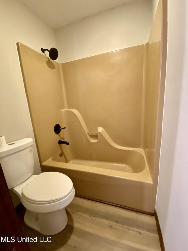 bathroom with toilet, tub / shower combination, and wood finished floors