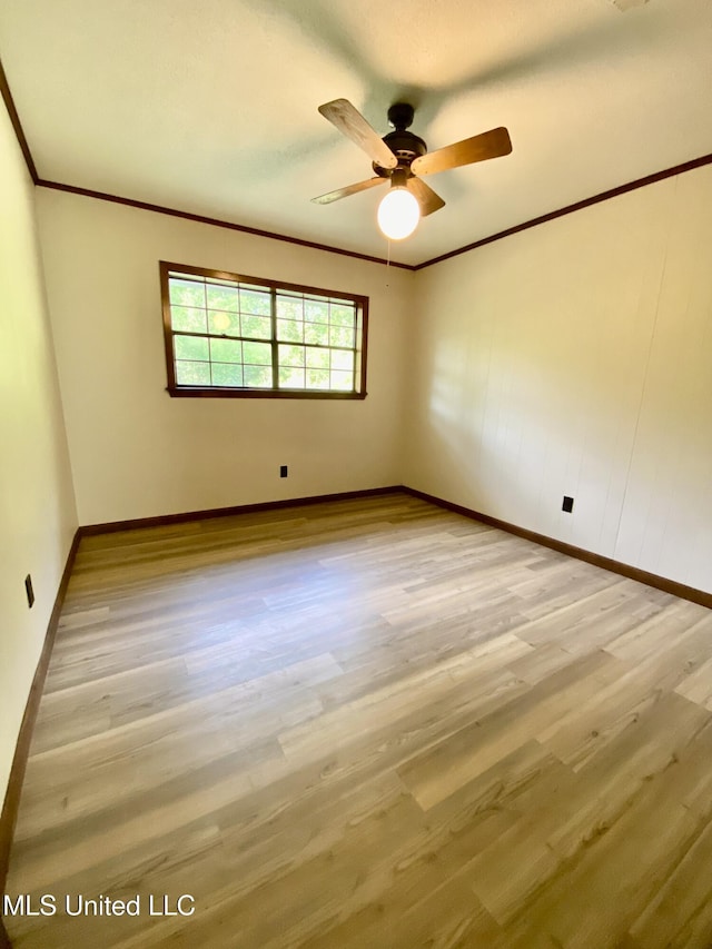 empty room featuring crown molding, a ceiling fan, baseboards, and wood finished floors