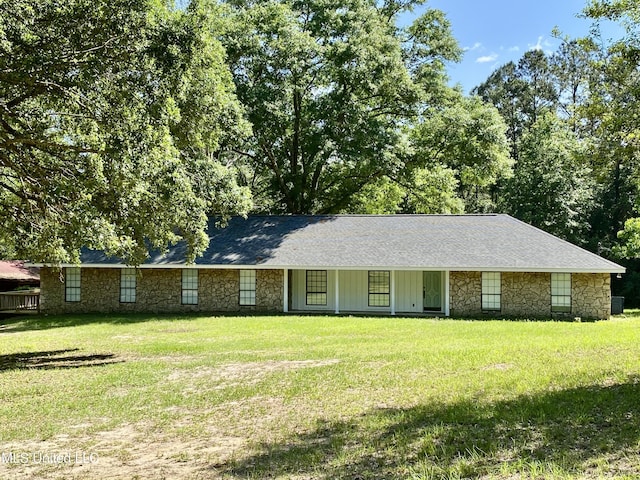 ranch-style house with a front yard, a shingled roof, and stone siding