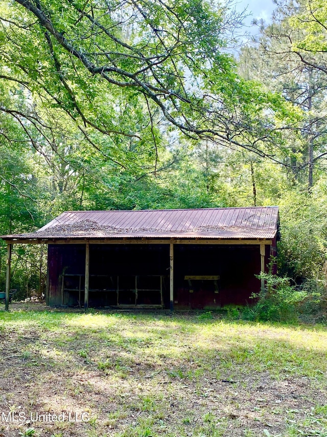 view of pole building with a carport and a forest view