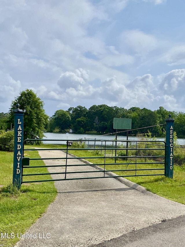 view of gate featuring a water view and fence
