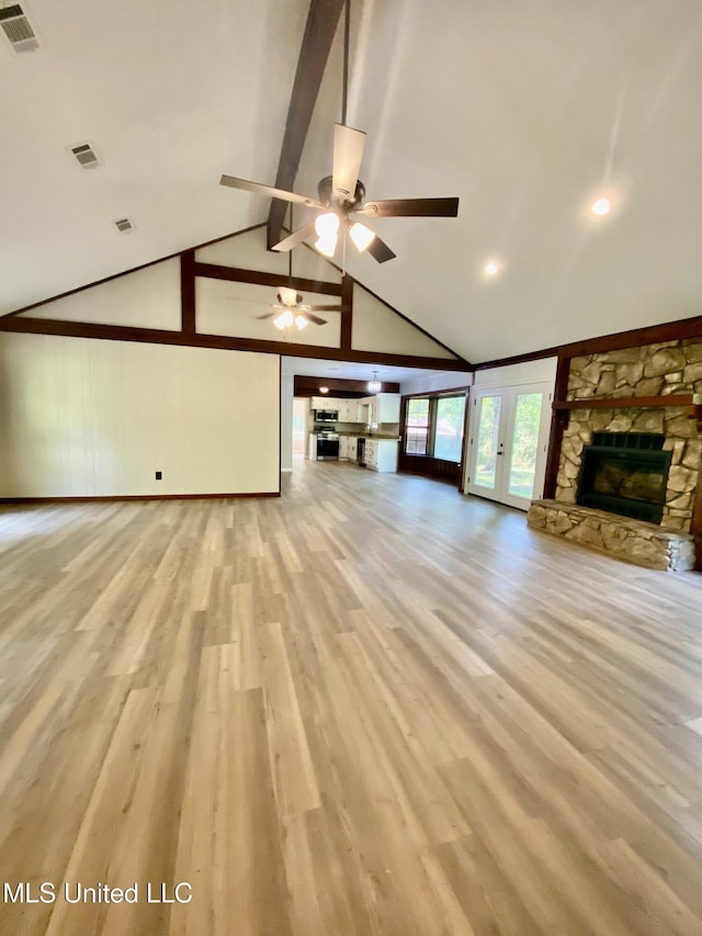 unfurnished living room featuring visible vents, a ceiling fan, wood finished floors, and a fireplace