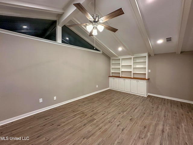 unfurnished living room with ceiling fan, hardwood / wood-style flooring, and vaulted ceiling with beams