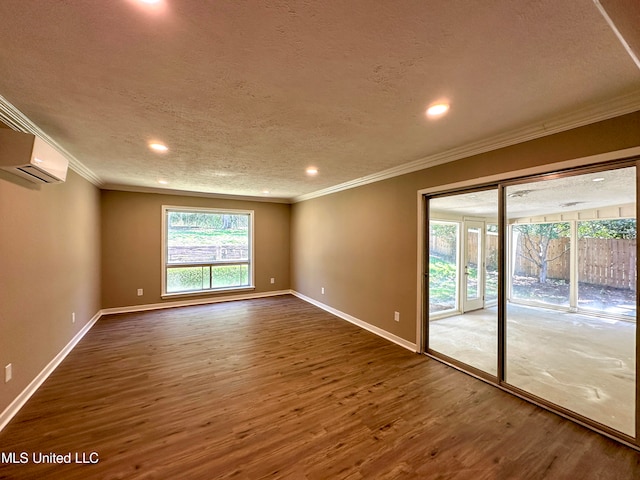 unfurnished room with dark wood-type flooring, crown molding, a textured ceiling, and a wall mounted air conditioner