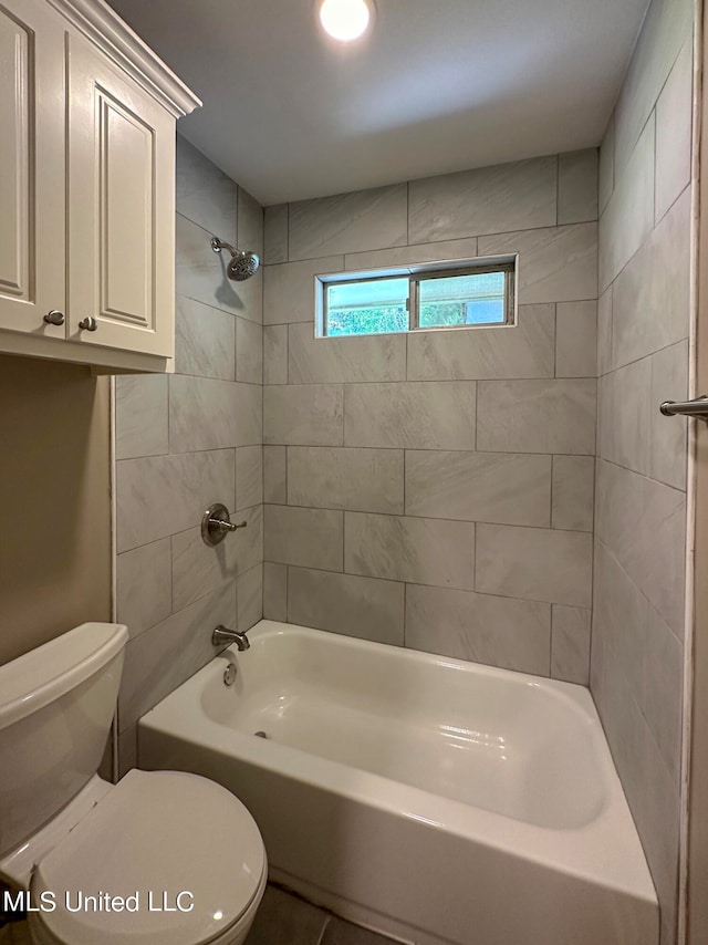 bathroom featuring tiled shower / bath and toilet