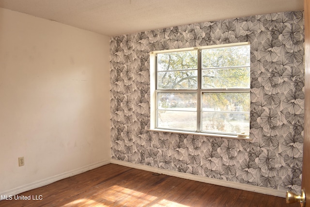 2201 15th Ave, Gulfport, MS 39501 - empty room featuring wood finished floors, baseboards, and wallpapered walls