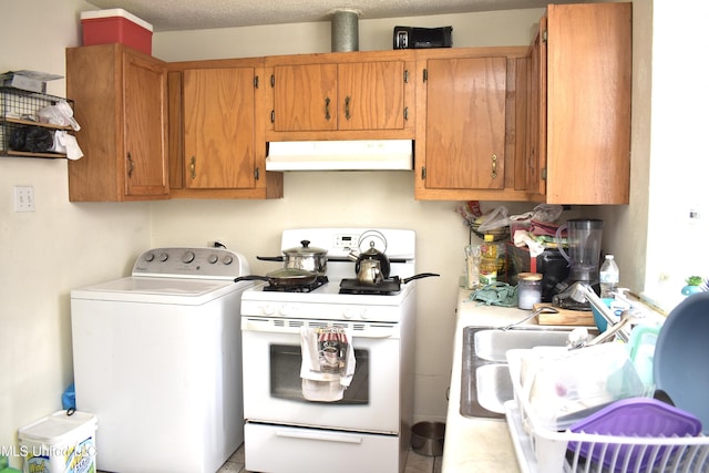 2201 15th Ave, Gulfport, MS 39501 - kitchen with washer / dryer, under cabinet range hood, white range with gas cooktop, light countertops, and brown cabinets