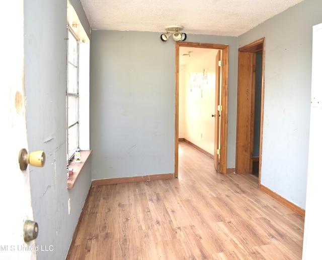 2201 15th Ave, Gulfport, MS 39501 - empty room featuring light wood finished floors, a textured ceiling, and baseboards