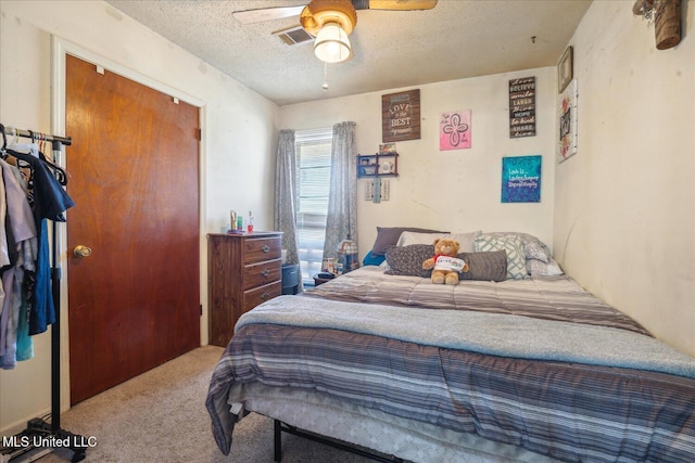 bedroom featuring ceiling fan, carpet flooring, and a textured ceiling