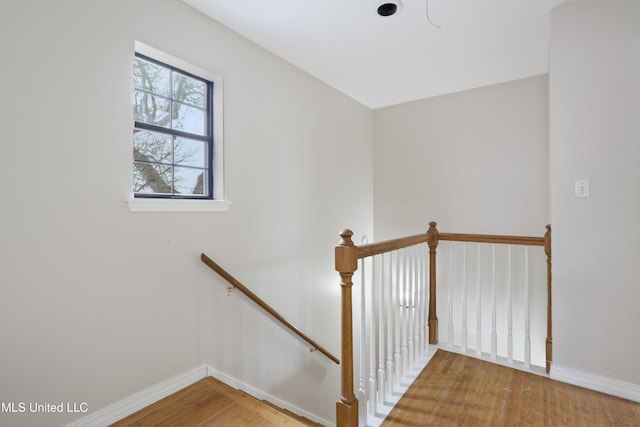 staircase featuring wood finished floors and baseboards