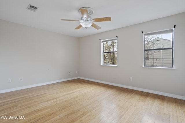 empty room with visible vents, baseboards, a ceiling fan, and light wood finished floors