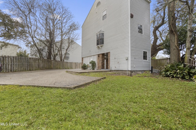 back of property with fence, a patio area, and a lawn