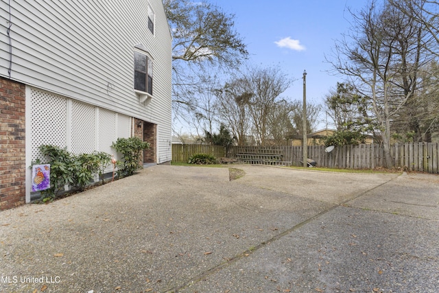 view of patio with driveway and fence