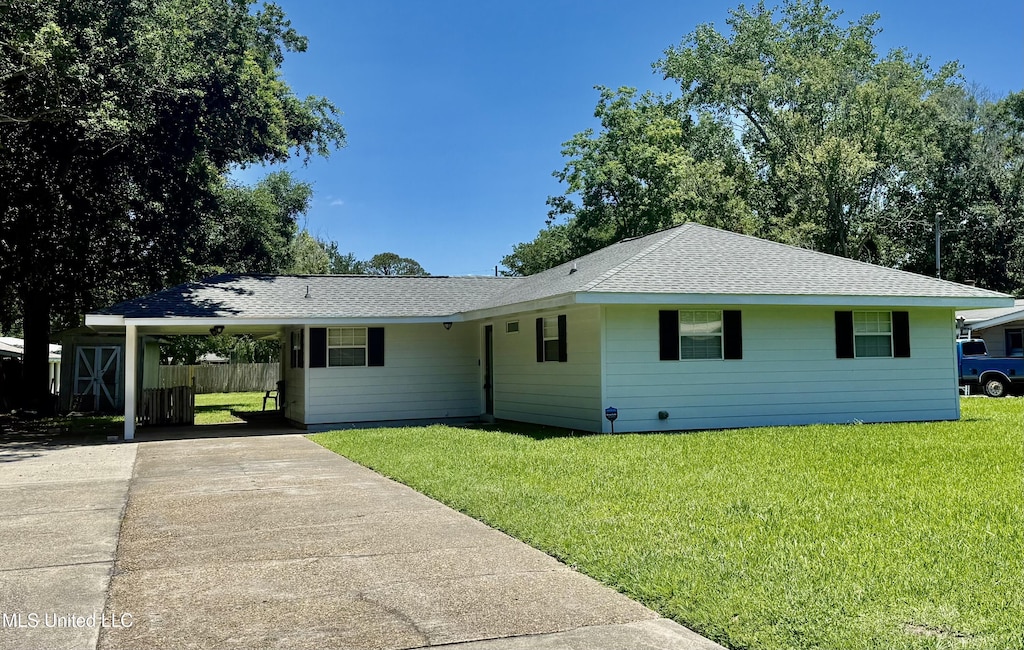 2609 Wilson Ave, Pascagoula, MS 39567 - single story home with concrete driveway, a front yard, a carport, and a shingled roof