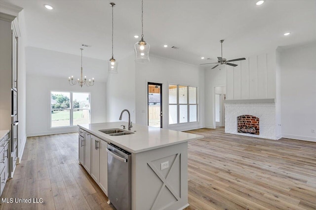 kitchen with hanging light fixtures, a center island with sink, white cabinetry, light hardwood / wood-style flooring, and dishwasher