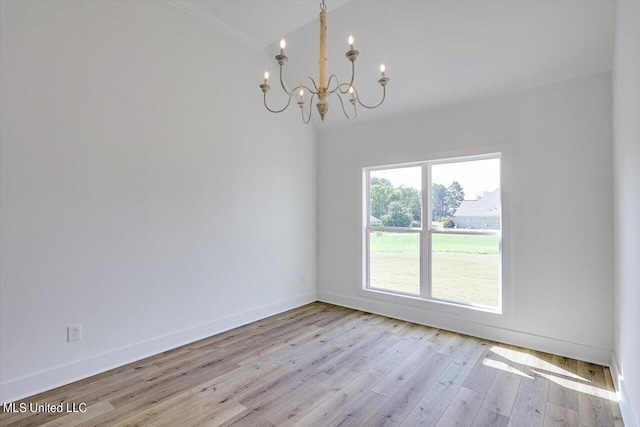 unfurnished room with baseboards, crown molding, a chandelier, and hardwood / wood-style floors