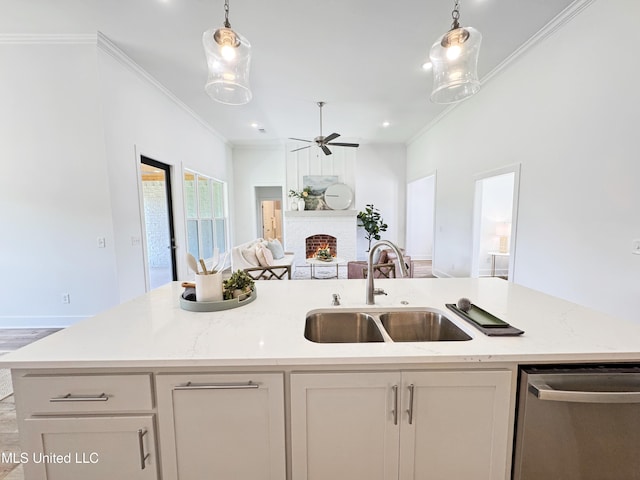 kitchen with a sink, open floor plan, dishwasher, ceiling fan, and a brick fireplace