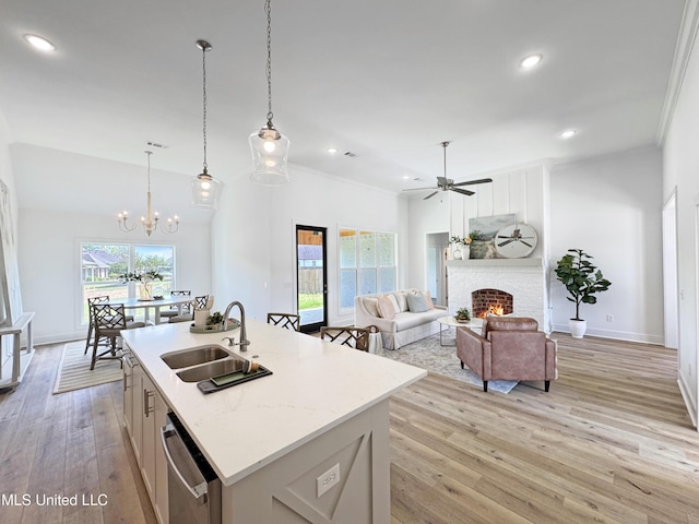kitchen featuring ceiling fan with notable chandelier, crown molding, stainless steel dishwasher, and a sink
