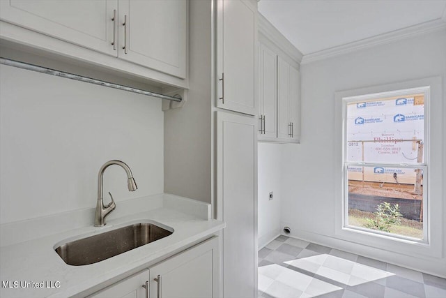 laundry area featuring cabinet space, ornamental molding, a sink, light floors, and electric dryer hookup