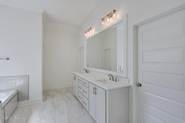 bathroom with vanity, ornamental molding, and a bathtub