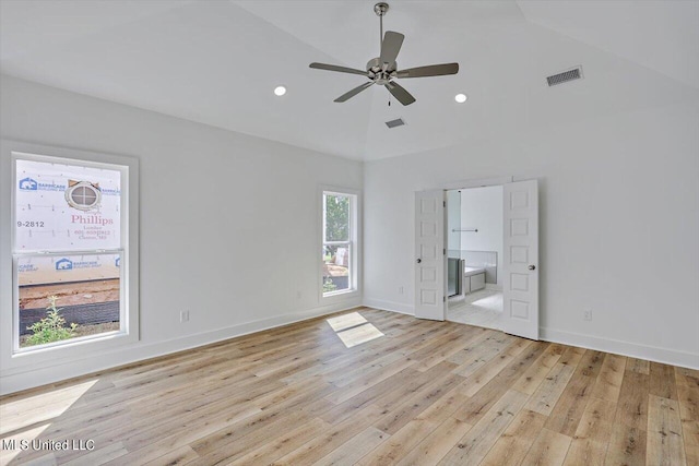 unfurnished bedroom with light wood finished floors, visible vents, ensuite bath, baseboards, and high vaulted ceiling