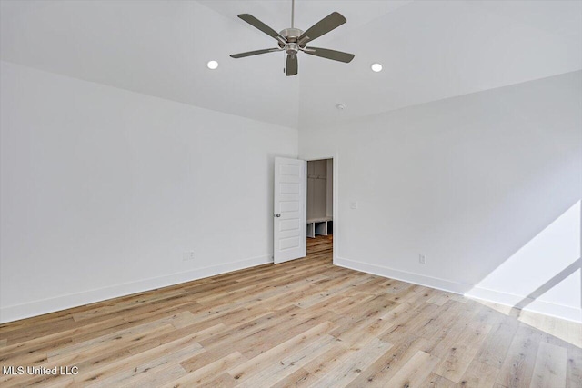 empty room with high vaulted ceiling, ceiling fan, baseboards, and light wood-style floors