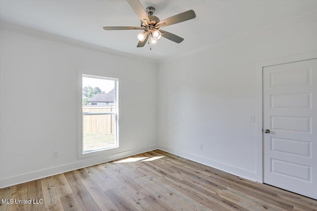 spare room featuring light wood-style flooring, a ceiling fan, baseboards, and ornamental molding