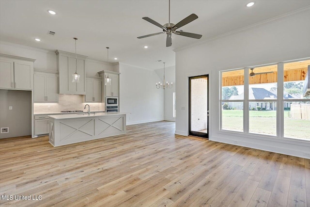 kitchen with tasteful backsplash, built in microwave, light wood-style floors, and crown molding