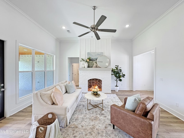 living area featuring light wood-style floors, visible vents, crown molding, and a ceiling fan