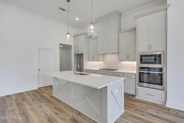 kitchen featuring gas cooktop, oven, a sink, built in microwave, and crown molding