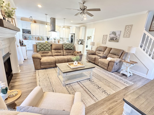 living room featuring ornamental molding, ceiling fan, and light hardwood / wood-style floors