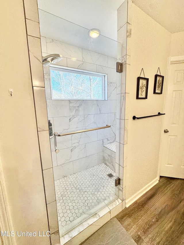 bathroom featuring wood-type flooring and a shower with door