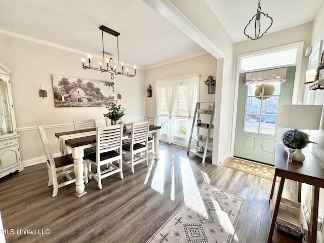 dining room with ornamental molding, dark wood-type flooring, and a chandelier