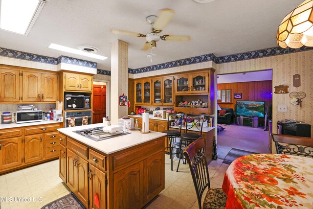 kitchen featuring ceiling fan, a center island, and white appliances