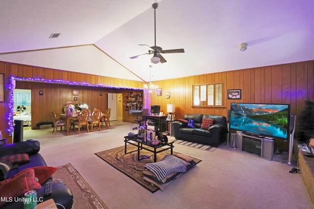 living room with ceiling fan, wood walls, carpet, and high vaulted ceiling