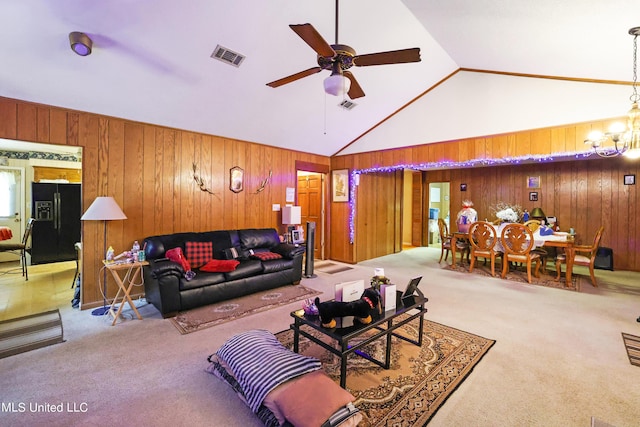 living area featuring visible vents, carpet, ceiling fan with notable chandelier, and wooden walls