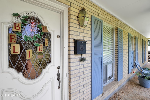 entrance to property with brick siding and covered porch