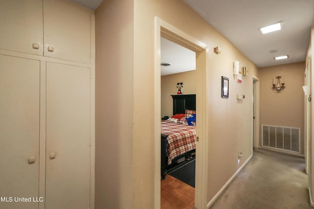 corridor with baseboards and visible vents