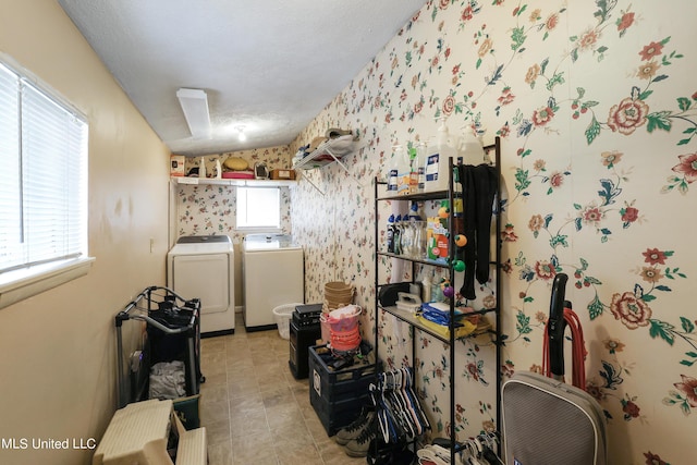 washroom with separate washer and dryer, laundry area, wallpapered walls, and a textured ceiling