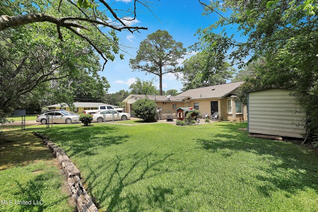view of yard with a shed, an outbuilding, and fence