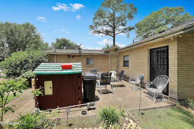 rear view of house with a patio, log exterior, and brick siding