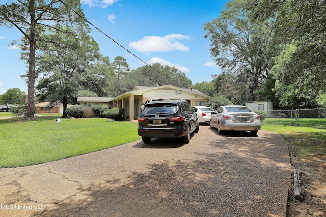 single story home with an attached garage, fence, a front yard, and concrete driveway