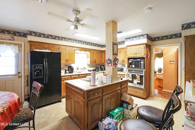 kitchen featuring light countertops, ceiling fan, black appliances, and wallpapered walls