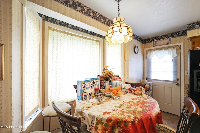 dining space featuring tile patterned floors and wallpapered walls