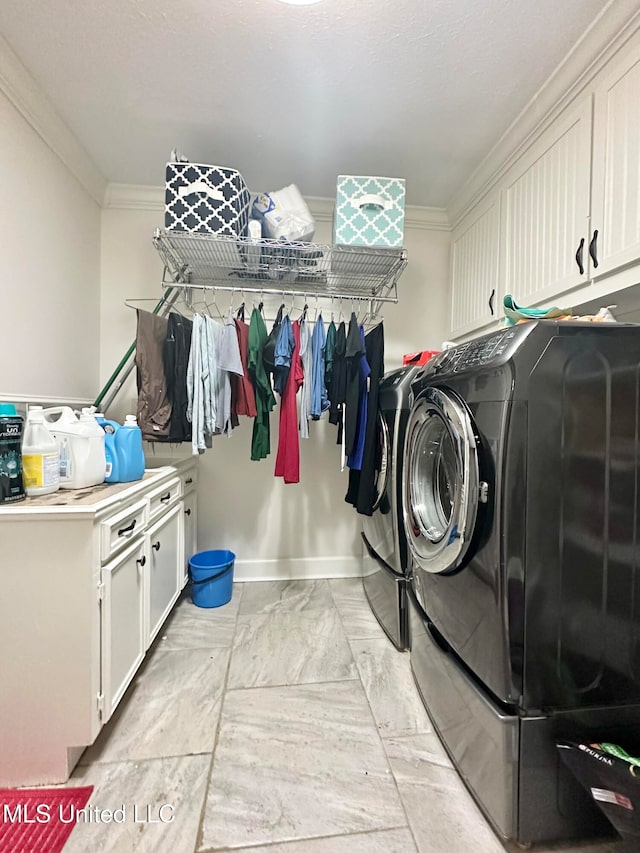 laundry room featuring separate washer and dryer, crown molding, and cabinets