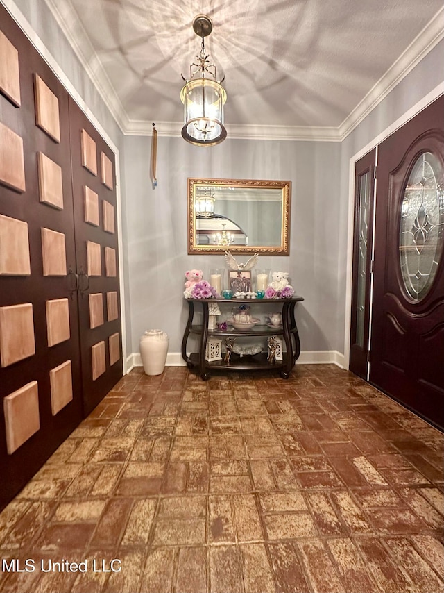 entryway with an inviting chandelier and crown molding