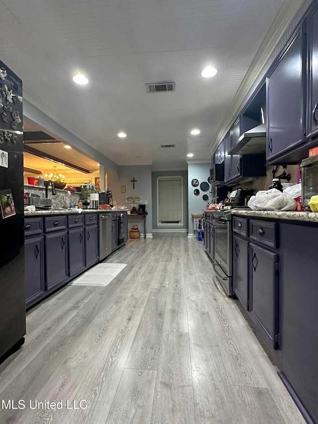 kitchen with appliances with stainless steel finishes and light hardwood / wood-style floors