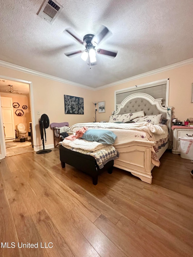 bedroom with a textured ceiling, light wood-type flooring, ceiling fan, and ornamental molding