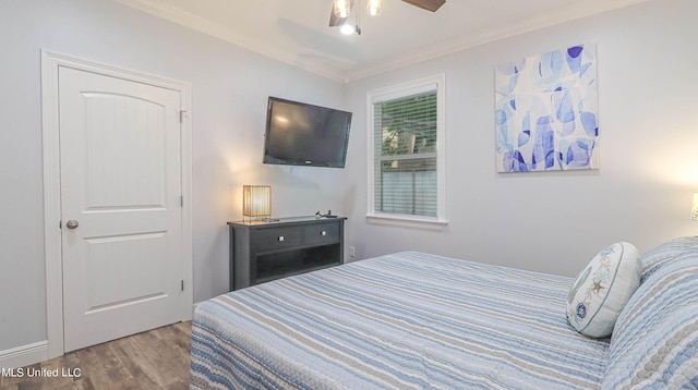 bedroom with ornamental molding, light hardwood / wood-style flooring, and ceiling fan