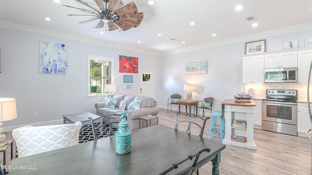 dining area with ornamental molding, light wood-type flooring, and ceiling fan